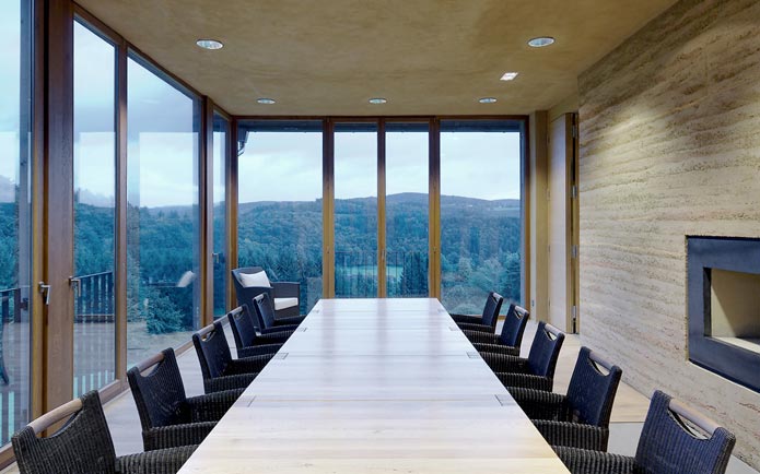 Das Kaminzimmer mit Fernblick und einem in der Stampflehmwand eingelassenen offenen Kamin (Foto: Thomas Koculak)