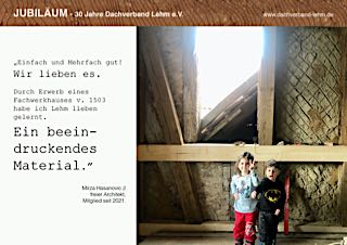 Ein Fachwerkwand mit rohem Lehmausfachung, davor zwei Kinder